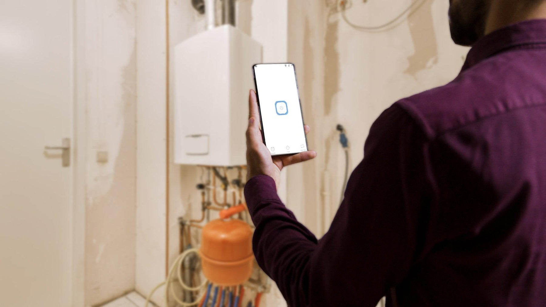 Man controls smart home energy device with smartphone in utility room