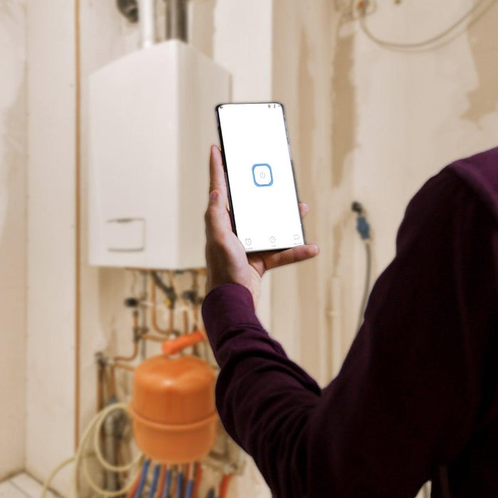 Man controls smart home energy device with smartphone in utility room