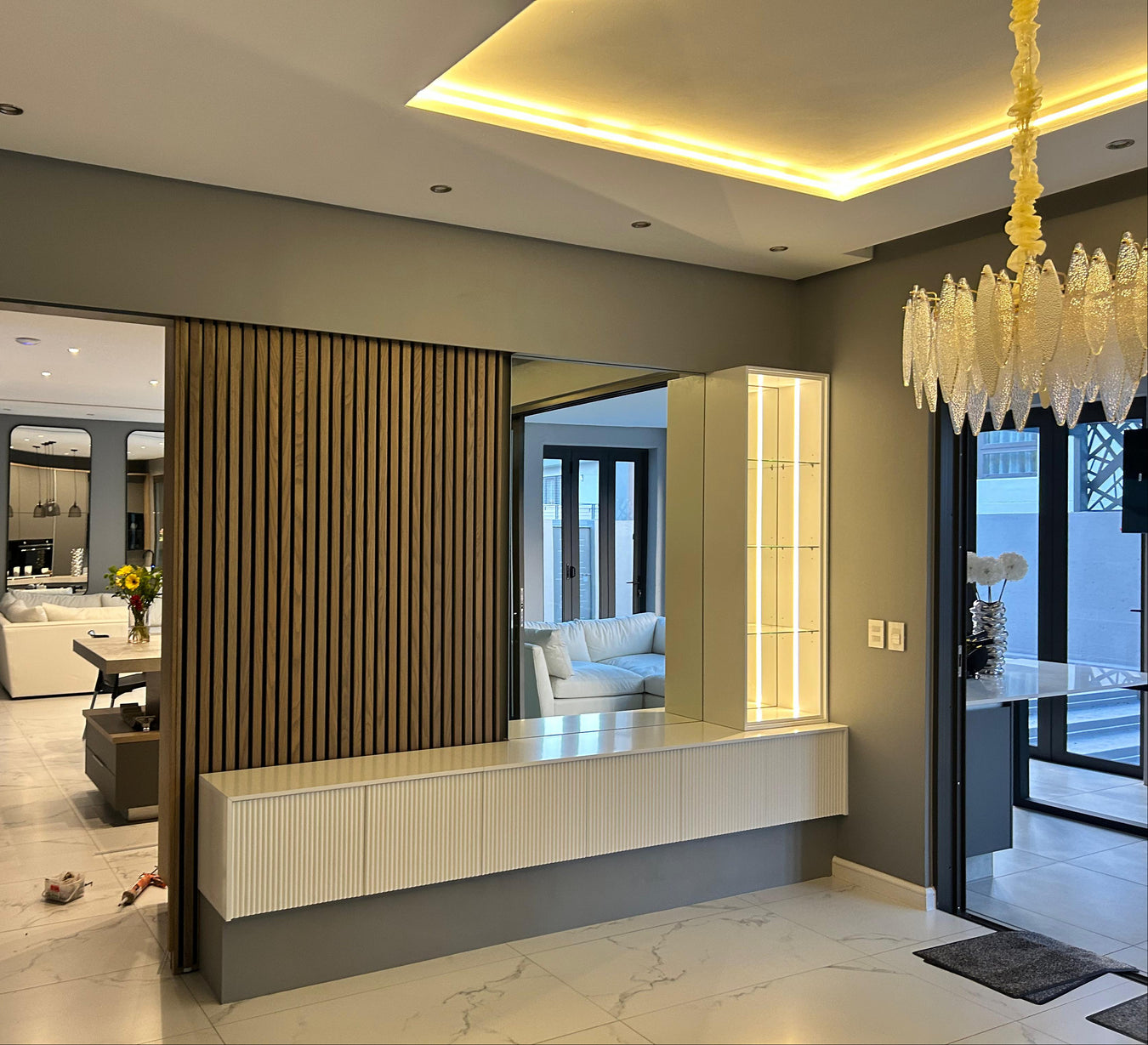 Modern interior design of a living room with a chandelier and decorative elements.