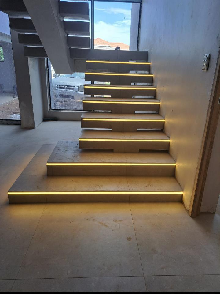 Modern staircase with embedded lighting in a well-lit room.